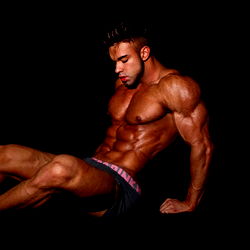 Krulagtige man in 'n ongewone posisie - Model Foto