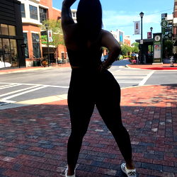 Pragtige Model in Swart, Stilstaande in Stad